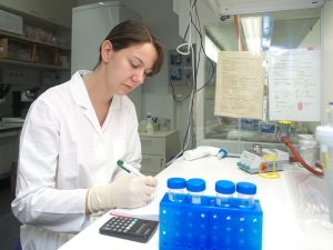 Eine Forscherin im Labor dokumentiert Ergebnisse; Genehmigungsverfahren